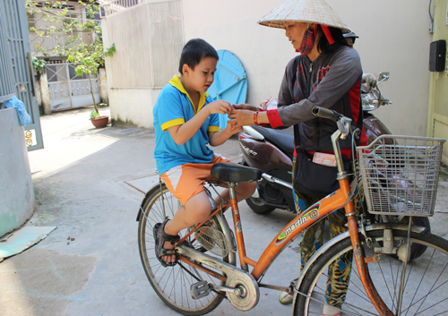 Hình ảnh cậu bé có khuôn mặt kháu khỉnh, đáng yêu được người mẹ chở bằng xe đạp. Ảnh: Lê Phương.