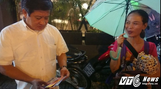 Ông Đoàn Ngọc Hải mua hết vé số cho người phụ nữ ẵm con nhỏ đi bán dưới mưa