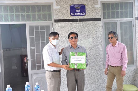 A group of people standing in front of a buildingDescription automatically generated