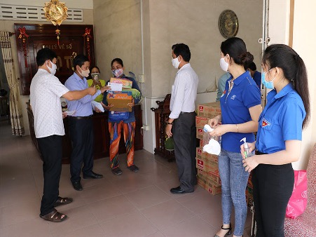 A group of people standing in a roomDescription automatically generated