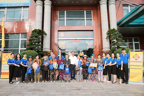 Công ty TNHH Nhà nước một thành viên Xổ số kiến thiết Cần Thơ: Tổ chức trao quà tặng gồm tập và áo mưa cho người bán vé số dạo trước trụ sở Công ty